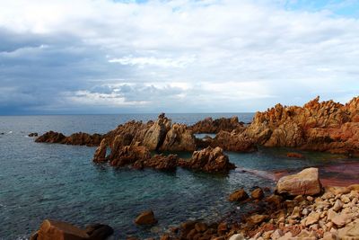 Rocks on sea shore against sky