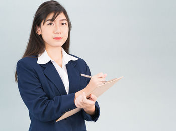 Portrait of young woman against white background