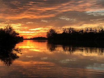 Scenic view of lake against orange sky