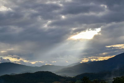 Scenic view of silhouette mountains against dramatic sky