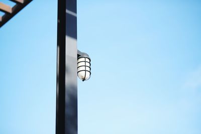 Low angle view of electric lamp against building
