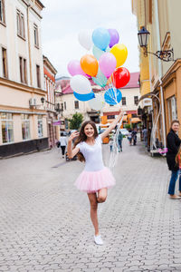 Full length of a smiling woman on street in city