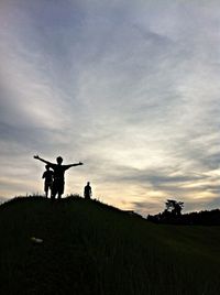 Man standing on landscape against cloudy sky