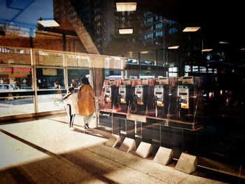Rear view of a woman walking on illuminated city at night