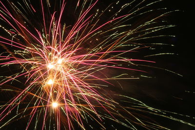 Low angle view of firework display against sky at night