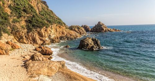 Scenic view of rocks in sea against sky