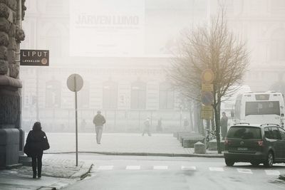 Woman walking on road in city