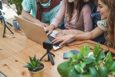 High angle view of friends using laptop at table 