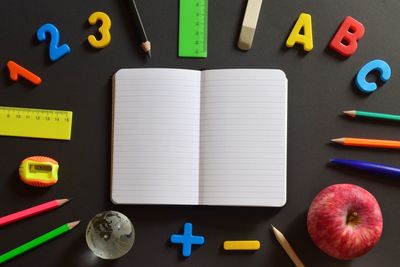 Directly above shot of book with colorful objects on table