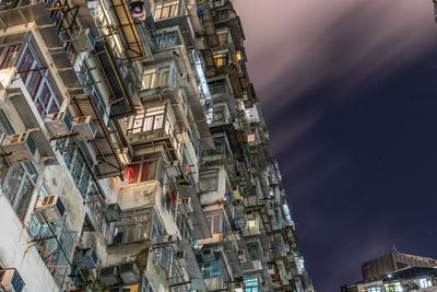 Low angle view of illuminated buildings against sky at night