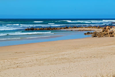 Scenic view of beach against clear sky