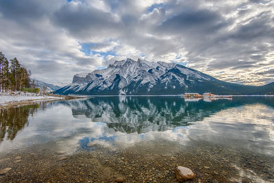 Scenic view of lake by snowcapped mountains against sky