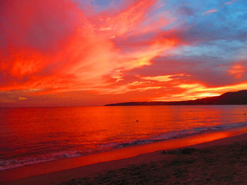 Scenic view of sea against dramatic sky during sunset