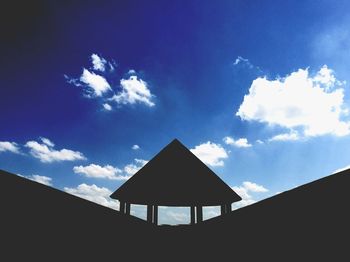 Low angle view of silhouette structure against blue sky