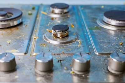 Dirty stove top with oil splatters, fat stains and food leftovers. unclean steel kitchen cooktop