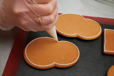 Cropped hand of person preparing food on table