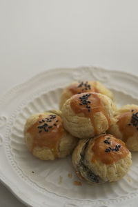There are some delicious black sesame egg yolk pastries freshly baked on the plate on the table