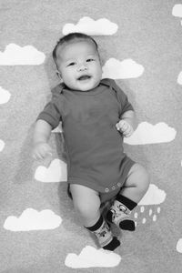 High angle portrait of smiling boy sitting on floor