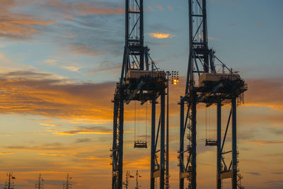 Low angle view of silhouette crane against sky during sunset