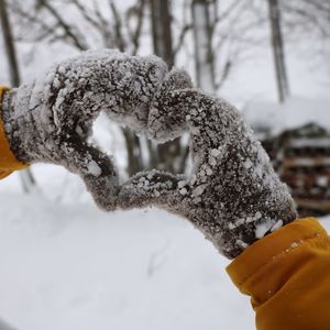 Cropped hands making heart shape during winter