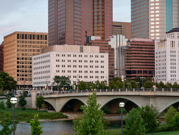 Bridge over river by buildings in city