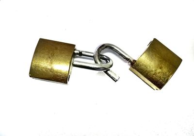 Close-up of padlocks on metal against white background