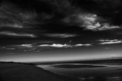 Scenic view of beach against dramatic sky