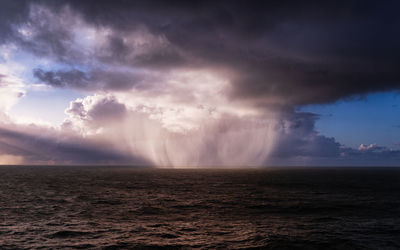 Phenomenon - the ocean feeds the clouds with a water. scenic view of sea against sky during sunset.