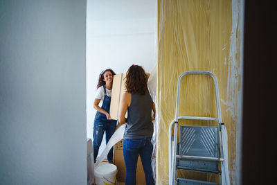 Young couple standing against wall