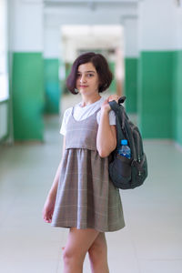 Portrait of young woman standing in city