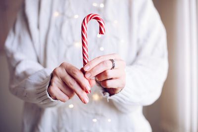 Close-up of woman holding candy cane