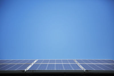 Low angle view of solar panel against blue sky
