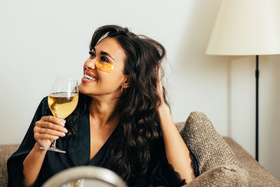 Close-up of woman holding wineglass at home