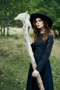 Portrait of young woman standing on field