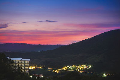 Illuminated buildings against sky during sunset