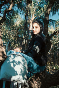 Teenager beautiful woman with a backpack in a tree