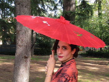 Portrait of woman holding red umbrella