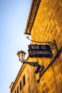 Low angle view of sign on building against sky