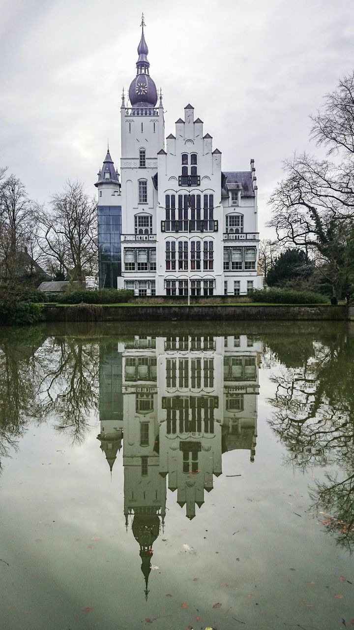 architecture, building exterior, reflection, built structure, water, waterfront, lake, tree, sky, standing water, river, building, day, city, pond, outdoors, tower, bare tree, no people, puddle