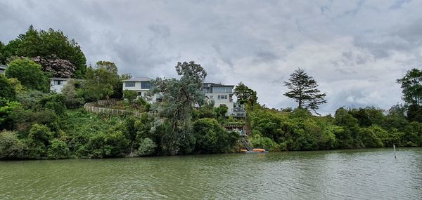 Scenic view of river by trees against sky