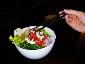 Close-up of hand holding salad in bowl