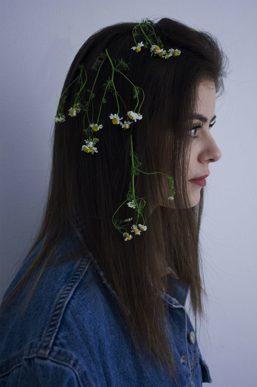 PORTRAIT OF WOMAN WITH PINK FLOWER