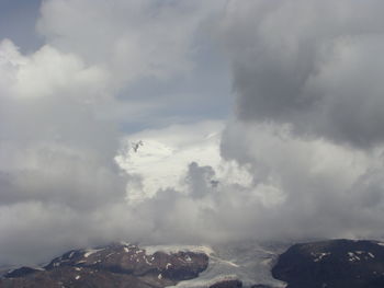Scenic view of mountains against cloudy sky