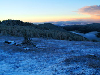 Scenic view of snowcapped mountains against sky during sunset
