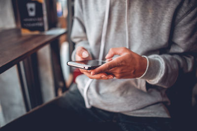 Midsection of man using mobile phone