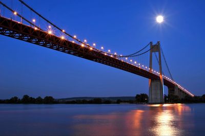 Low angle view of illuminated bridge over sea