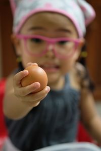 Close-up portrait of girl holding camera