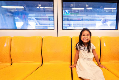 Portrait of smiling girl sitting in train