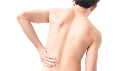 Rear view of shirtless man standing against white background