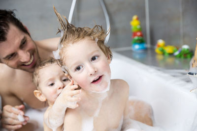 Father having fun with sons in bathtub